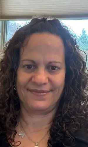 A woman with curly hair and a smile.