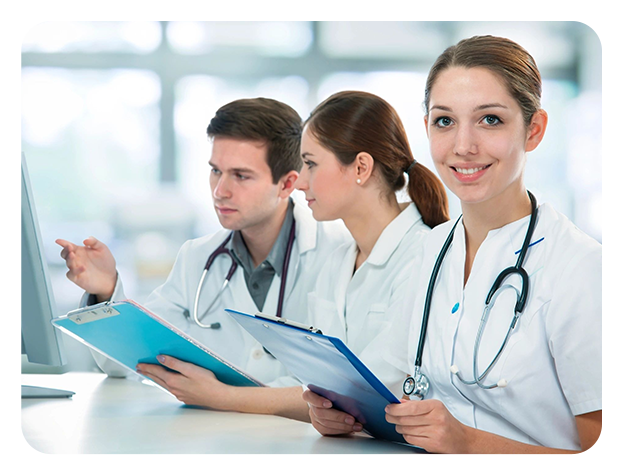 Three doctors are sitting at a table with papers.